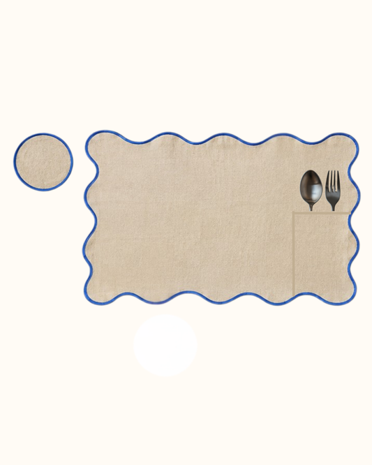 Roquefort linen set of eight, four placemats and four coasters in cream linen piped in deep blue.