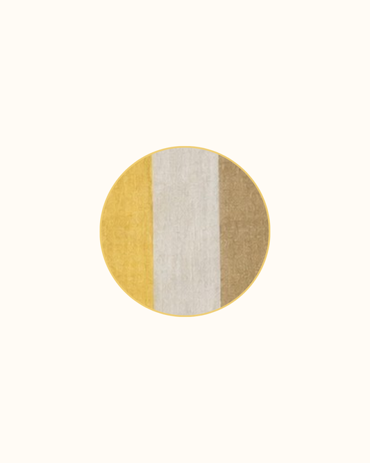 Four round linen coasters in Miso Butter, mustard through cream into deep ochre, piped in butter yellow.